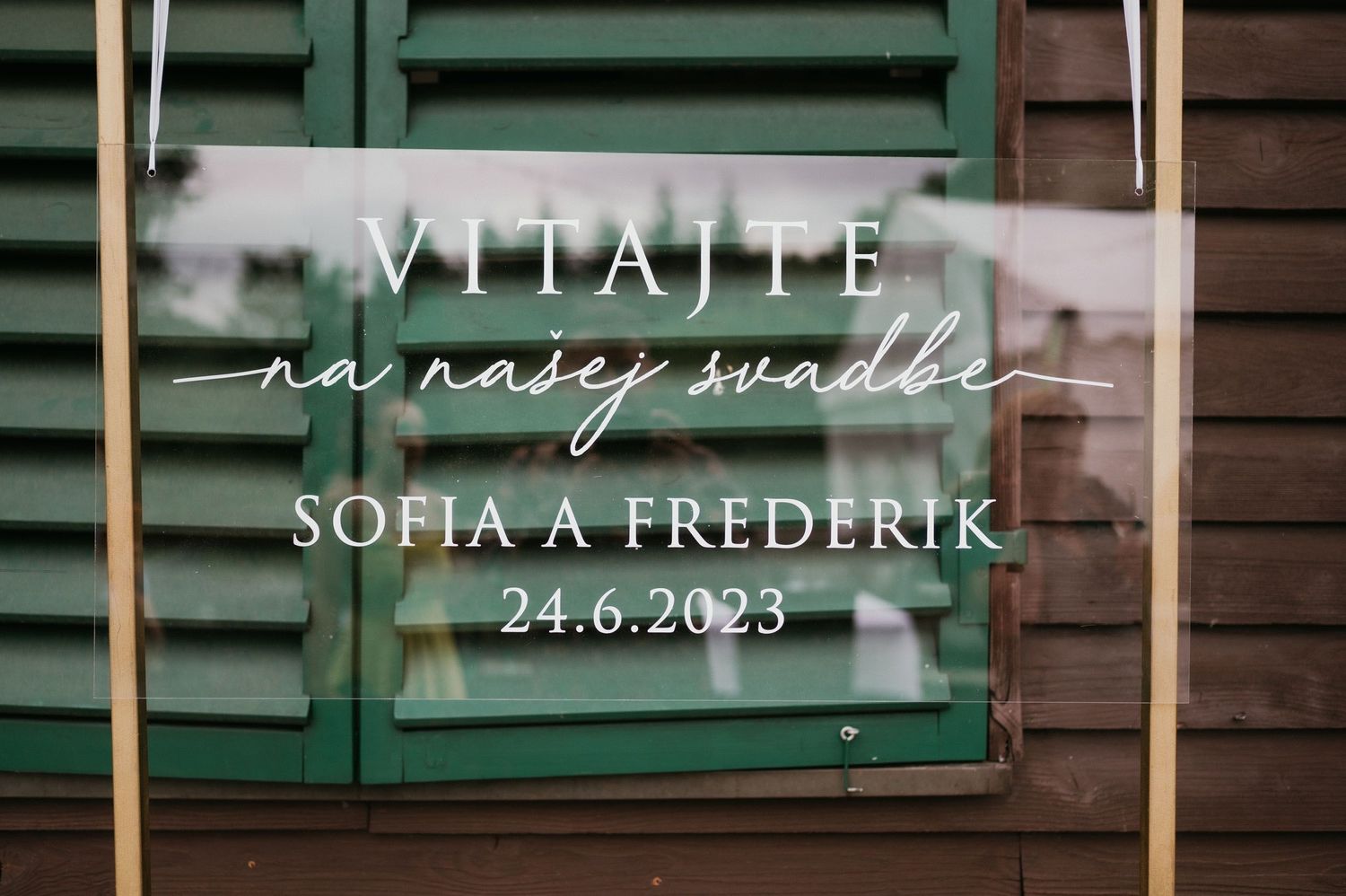 A wedding sign for Sofia and Frederik's celebration displayed on green wooden shutters.