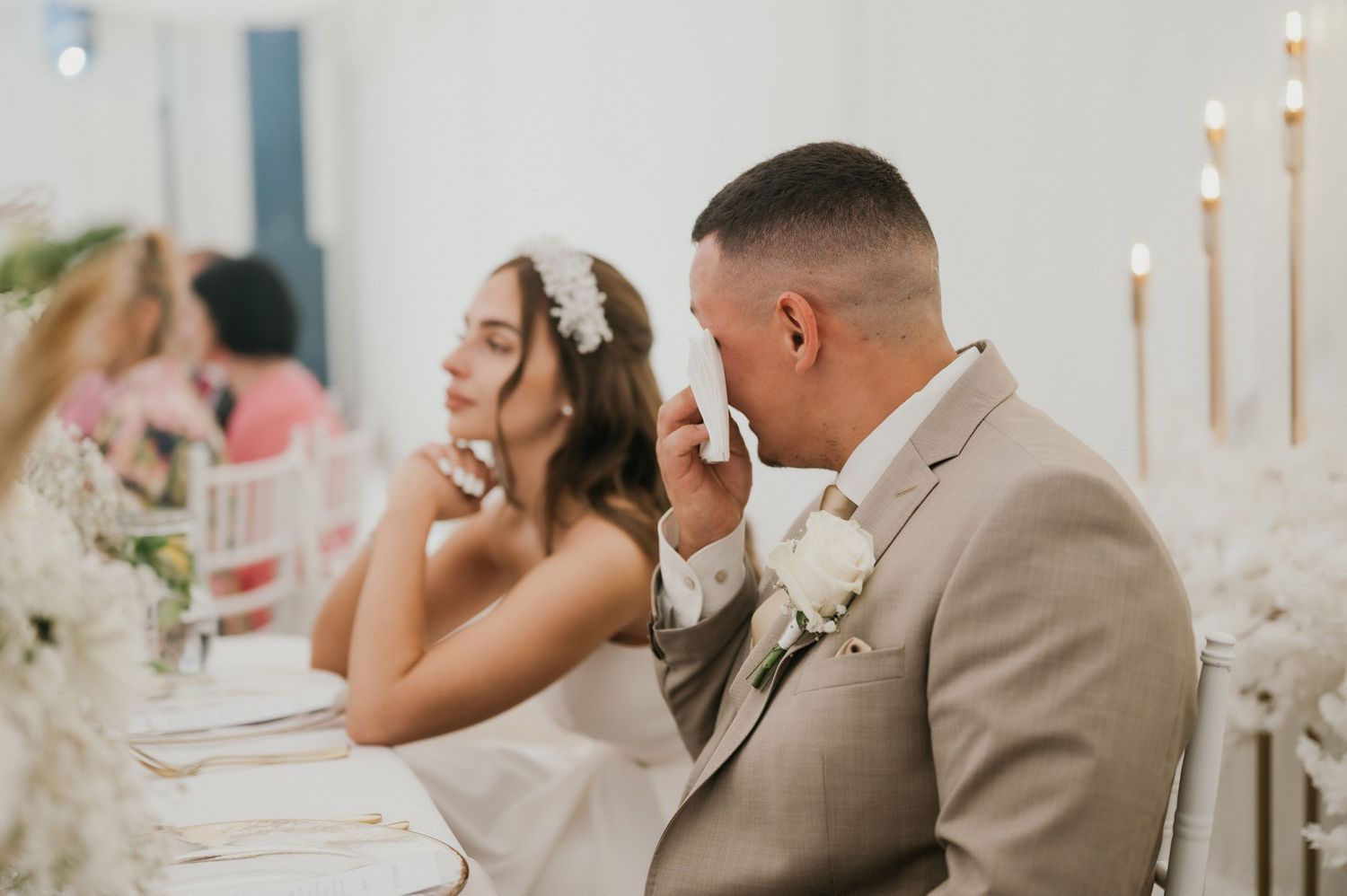 A candid reception moment showing laughter at an elegantly decorated wedding table.