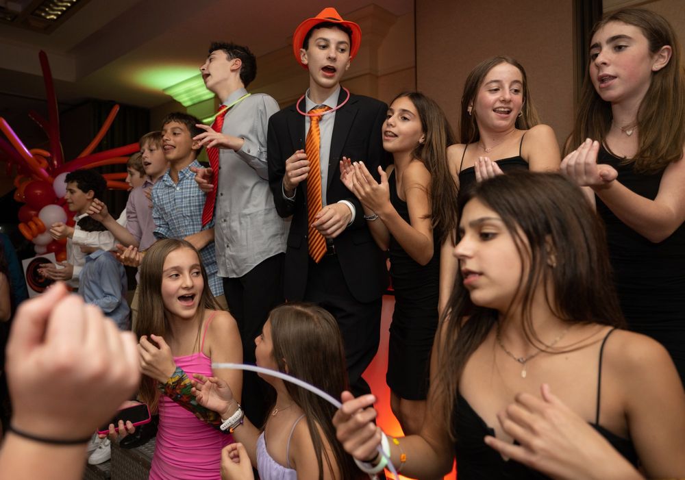 People enjoying themselves on a dance floor with red ambient lighting and festive atmosphere.