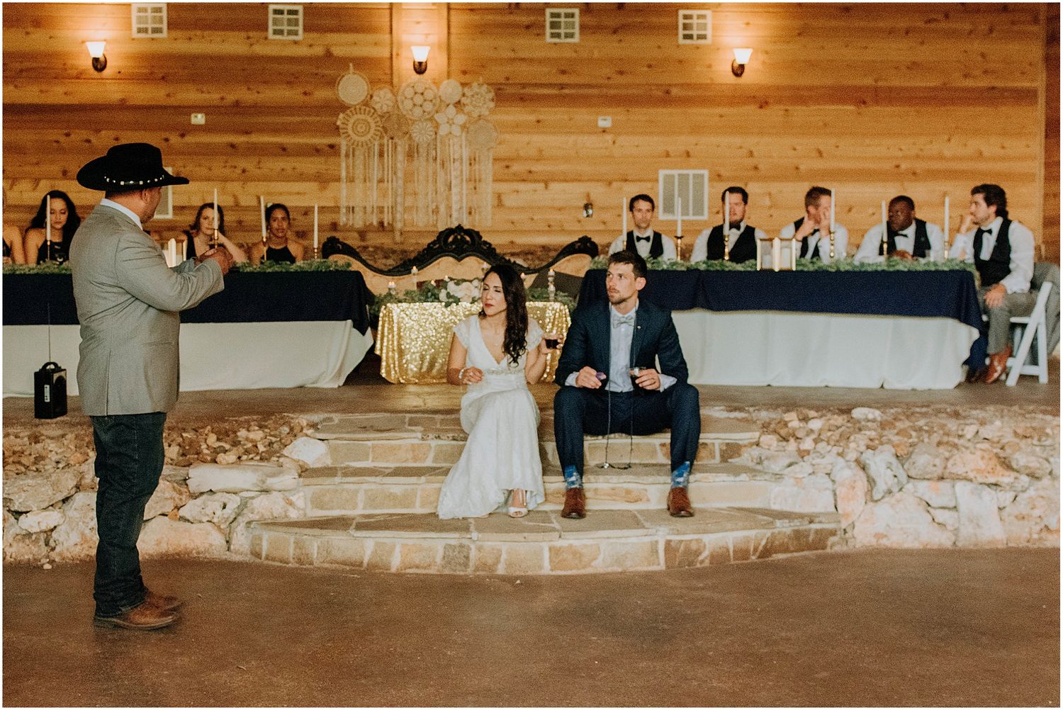 A wedding celebration moment in a rustic barn venue with stone steps and wooden wall panels.