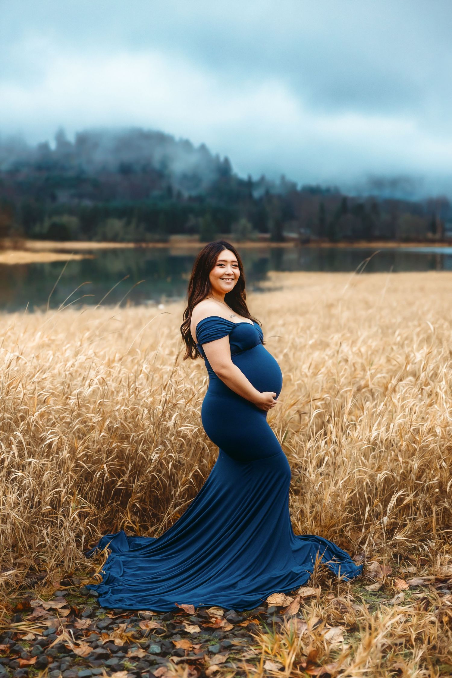 form fighting maternity dress in big field with lake view