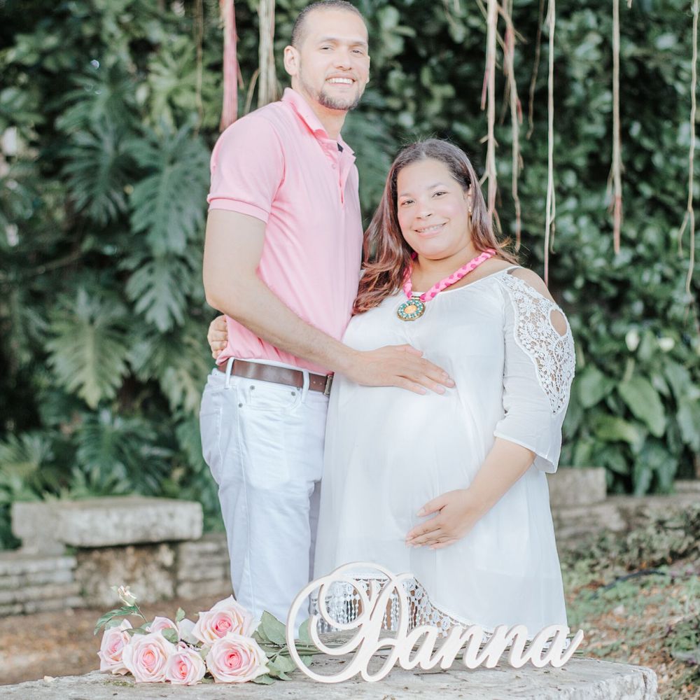 A couple poses together in a garden setting with pink roses and decorative text overlay.