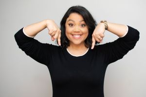Woman in black top with white trim making energetic poses and expressions.