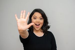 Woman showing different hand gestures and facial expressions in black outfit.