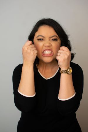 Woman in black outfit displaying range of emotional expressions from playful to intense.