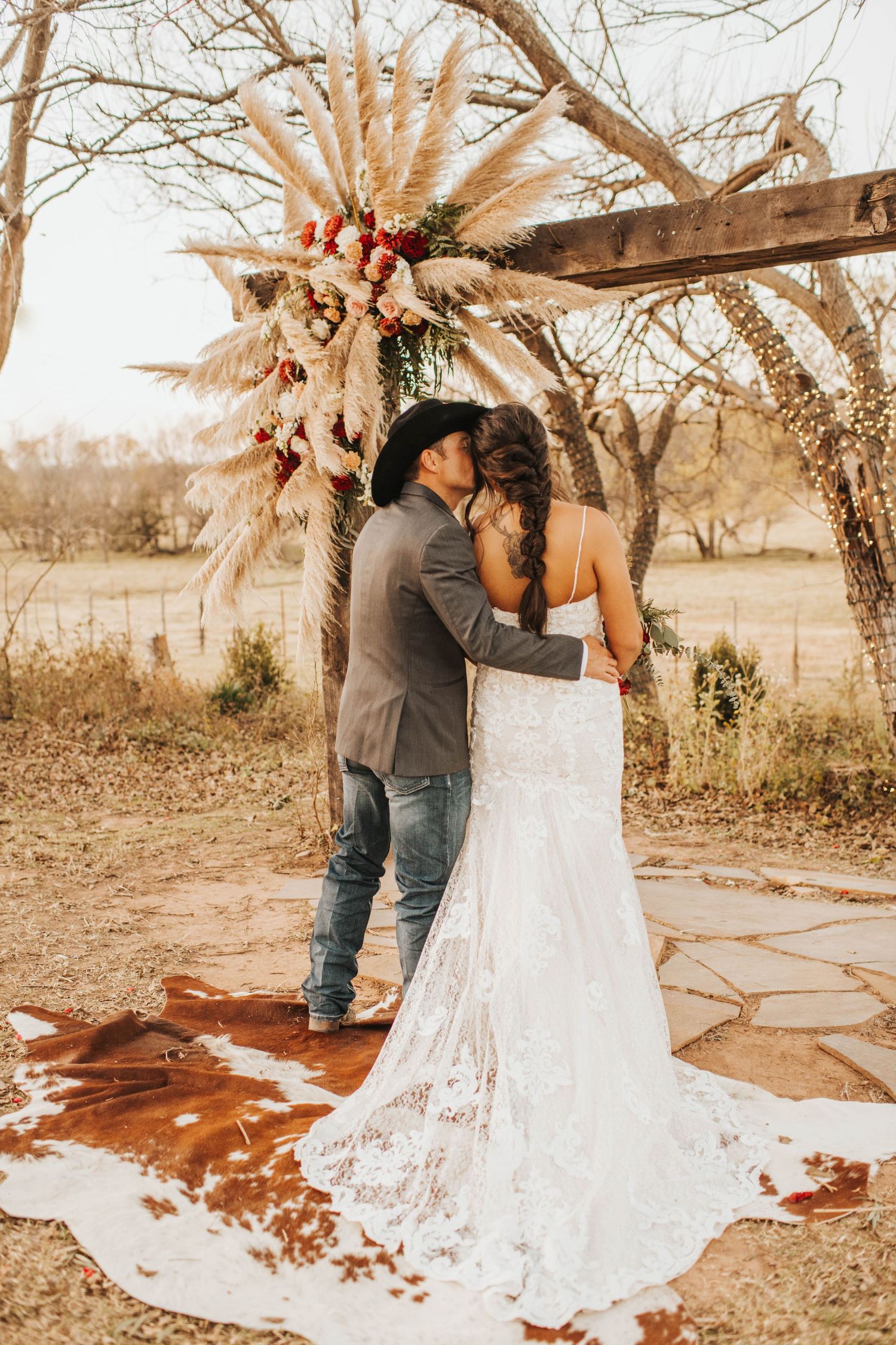 Bride and groom shot from behind with a rustic farm in the background