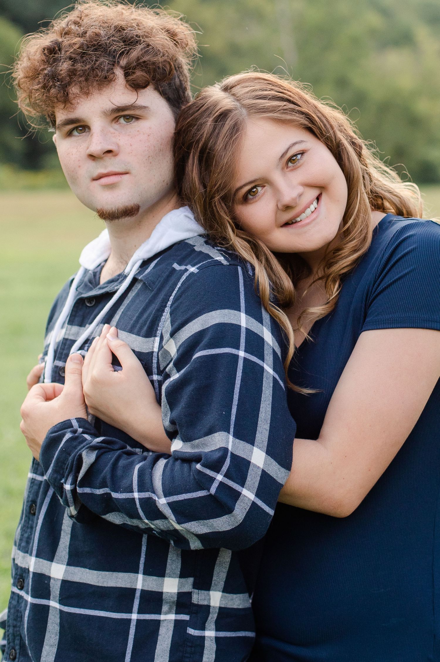 Couple in plaid and navy embracing in a series of sweet outdoor portraits.