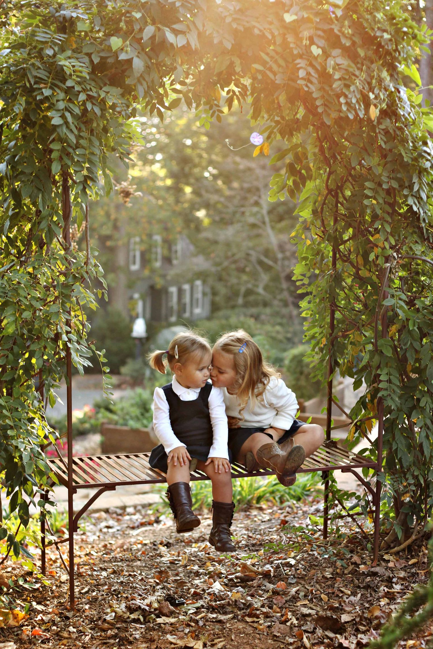 sisters kissing on a bench by victoria leigh photography