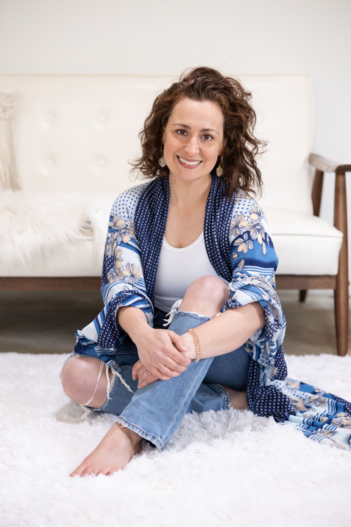 woman life coach sitting on floor in front of couch lifestyle headshot in Woodinville, WA