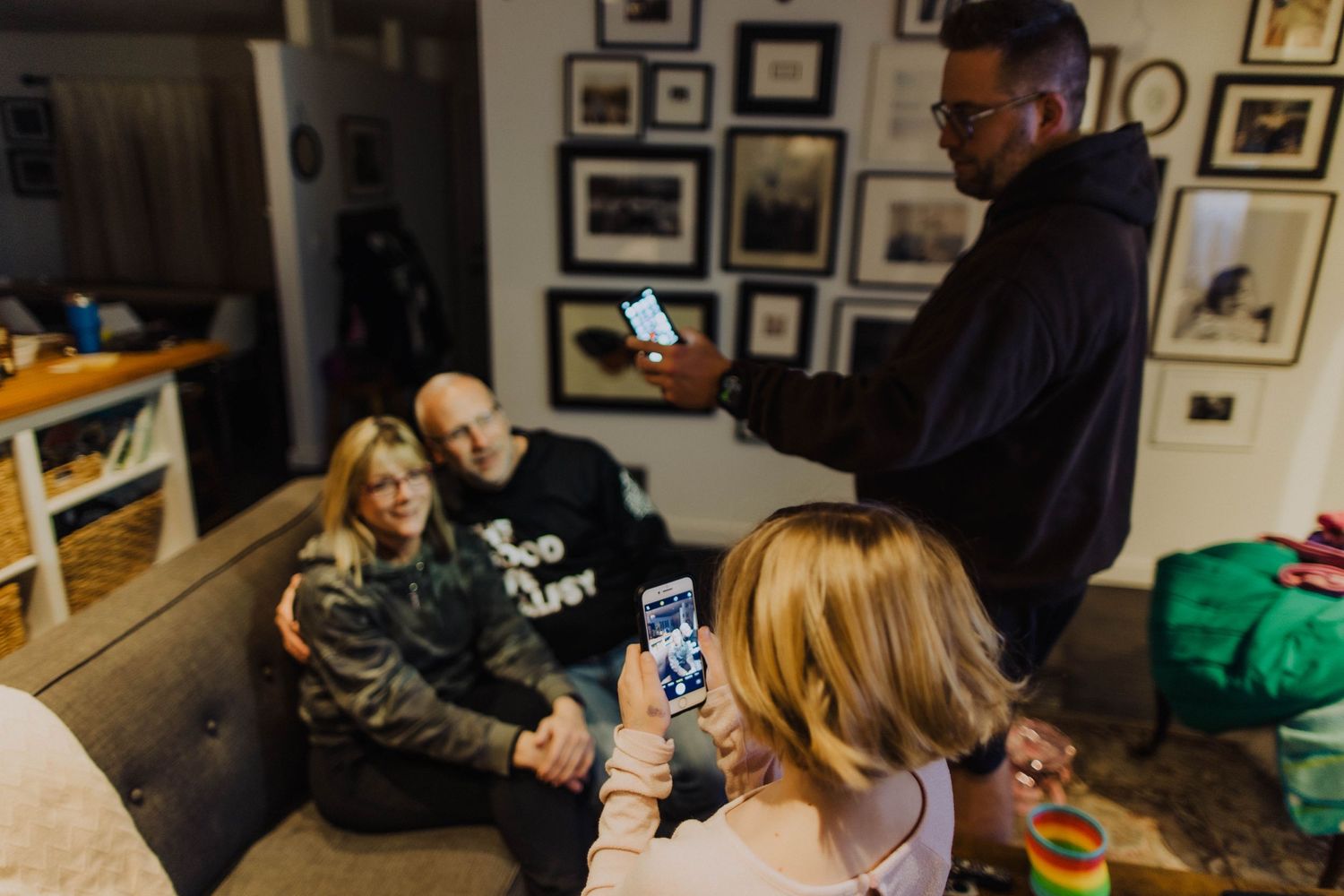 People relaxing in a living room while using mobile devices.