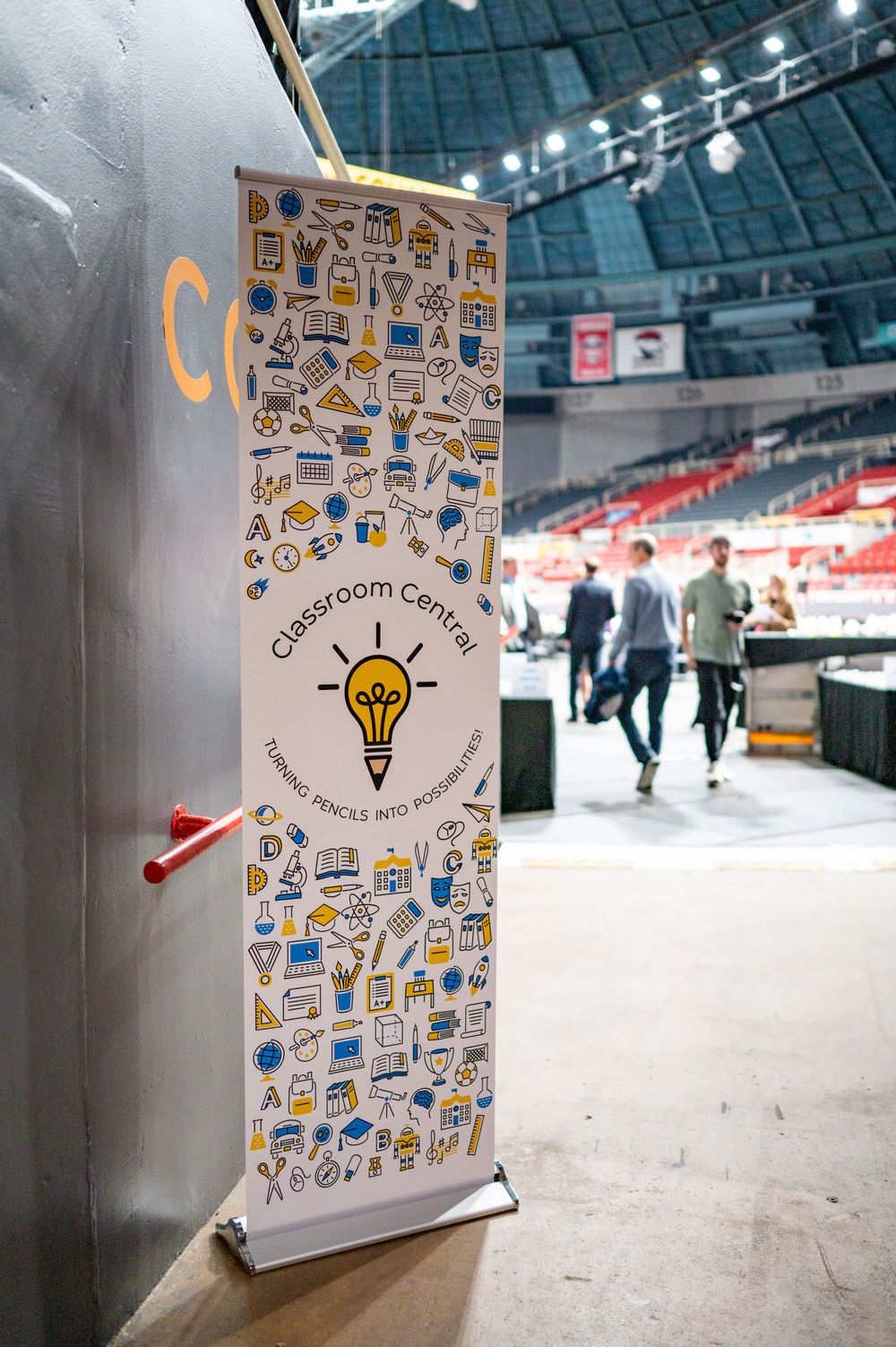 Event banner with creative icons and lightbulb design displayed in an arena setting.