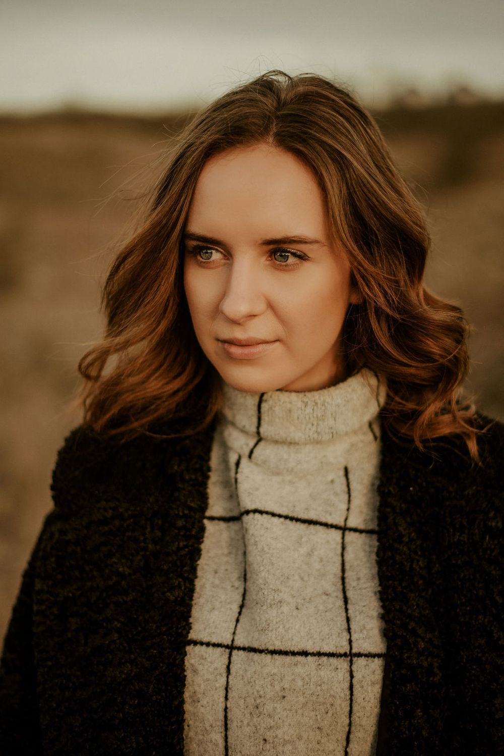 Warm-toned portrait series featuring a black coat and patterned sweater.