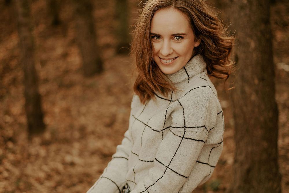 Stylish winter portrait in windowpane sweater with golden hour lighting.