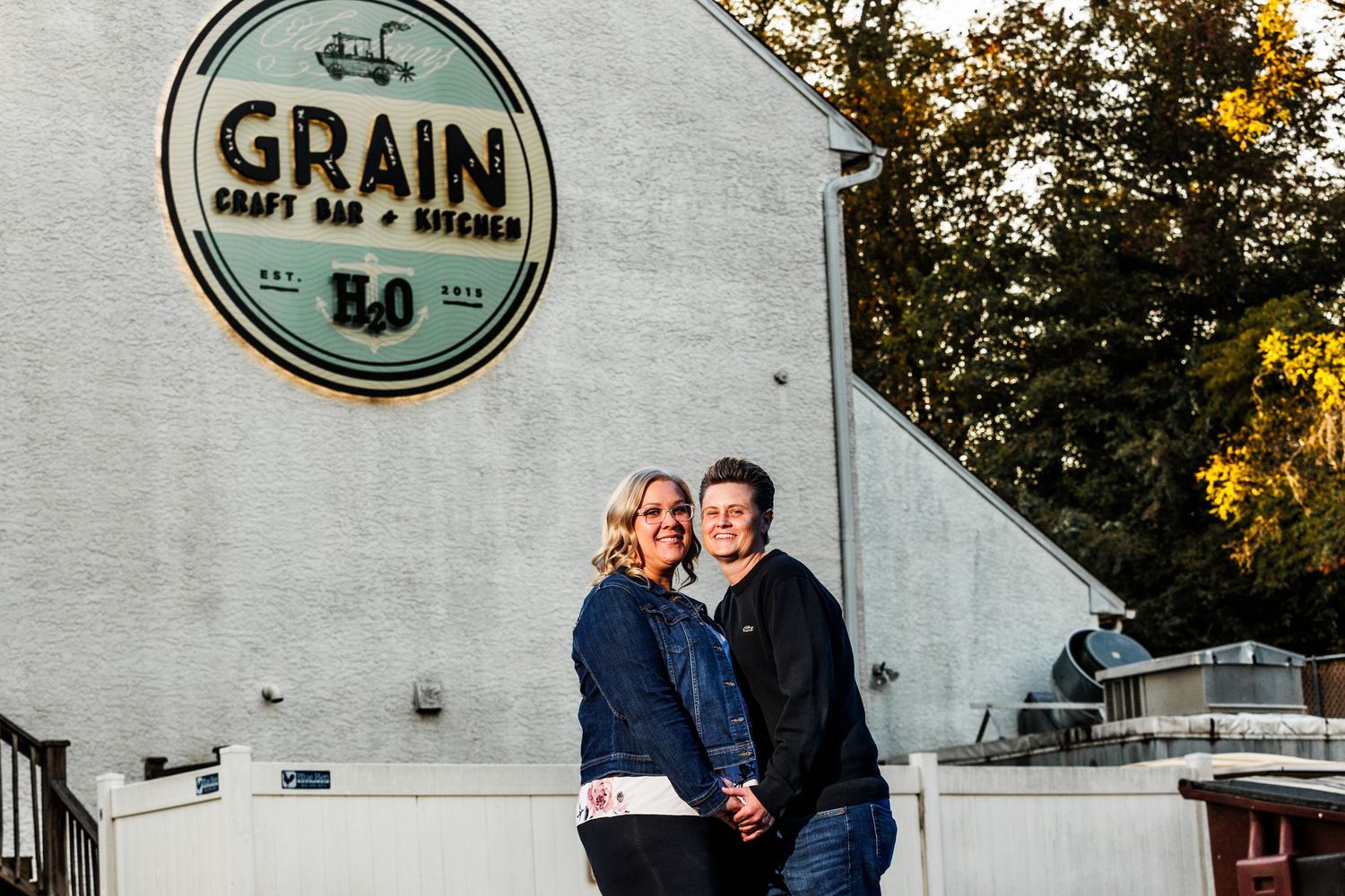 Couple posing together in front of Grain Craft Bar and Kitchen restaurant exterior.