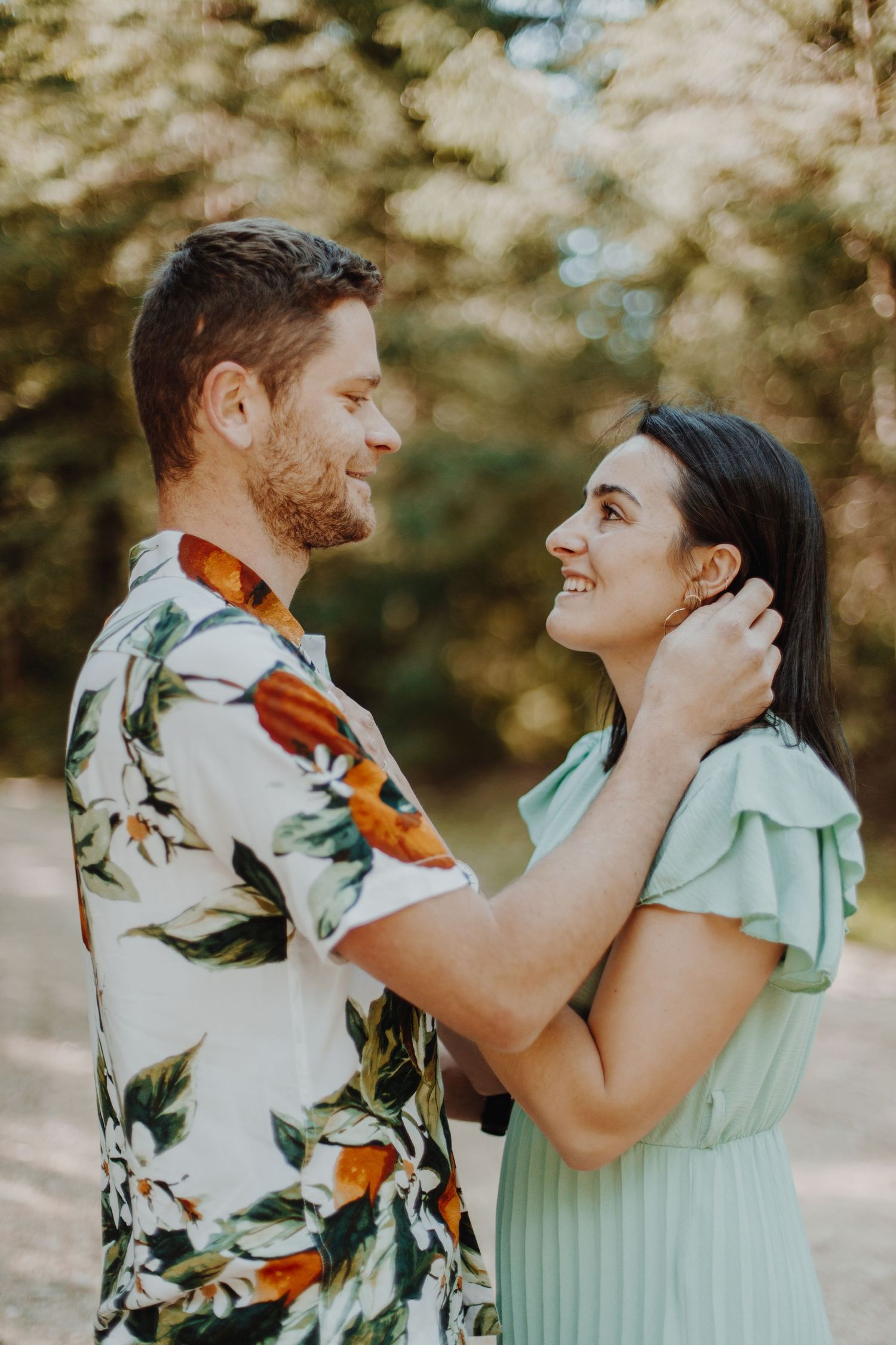 A romantic outdoor couple photoshoot with floral patterns and mint green clothing.