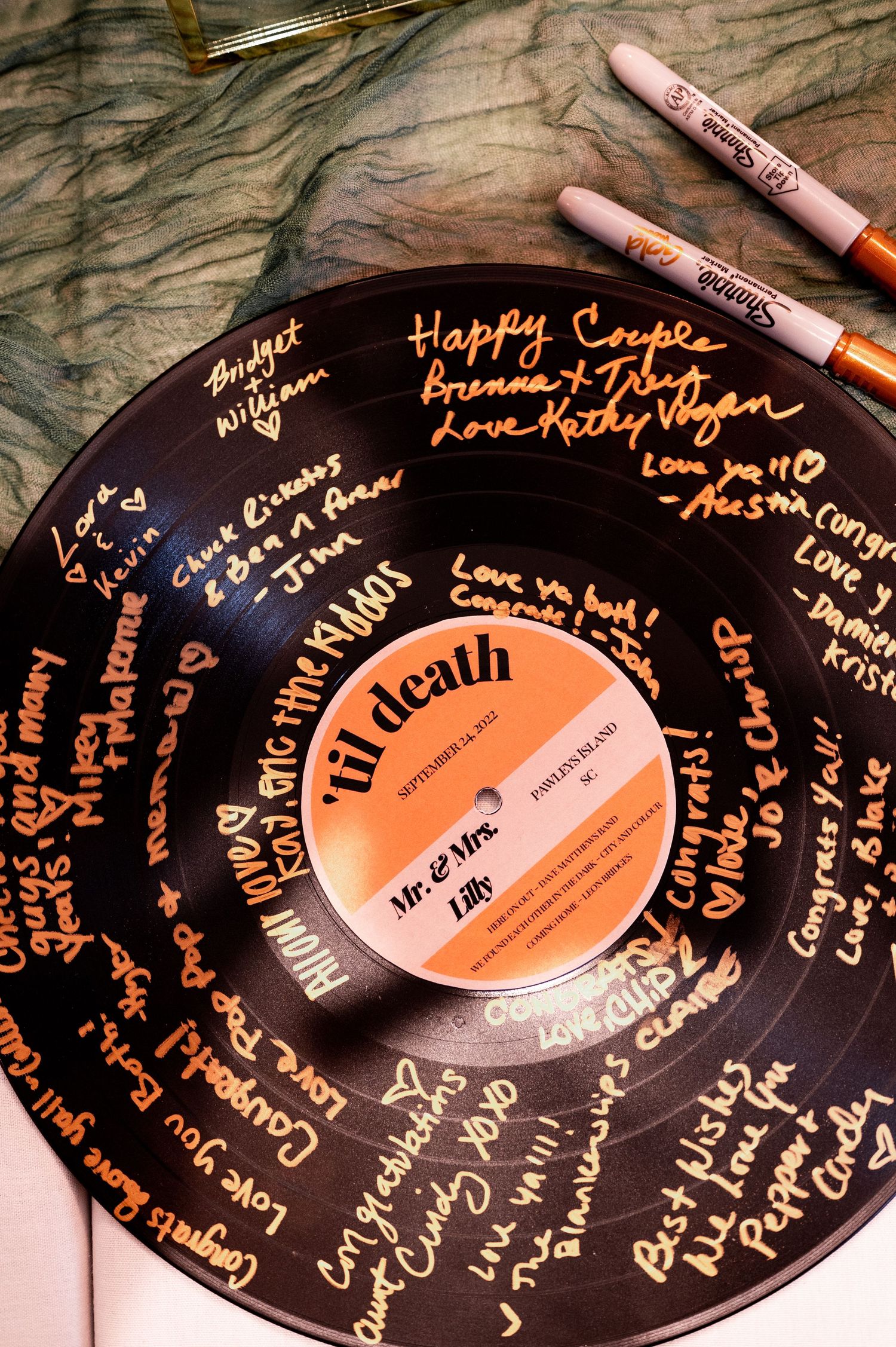 Vinyl record signed with golden messages serving as unique wedding guestbook.