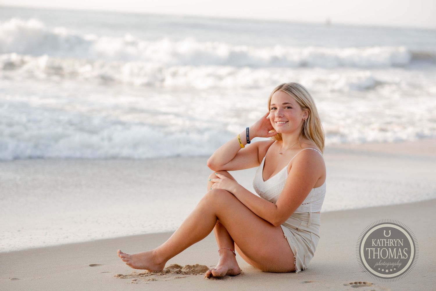 Beach portrait at golden hour with rolling waves and soft natural lighting.
