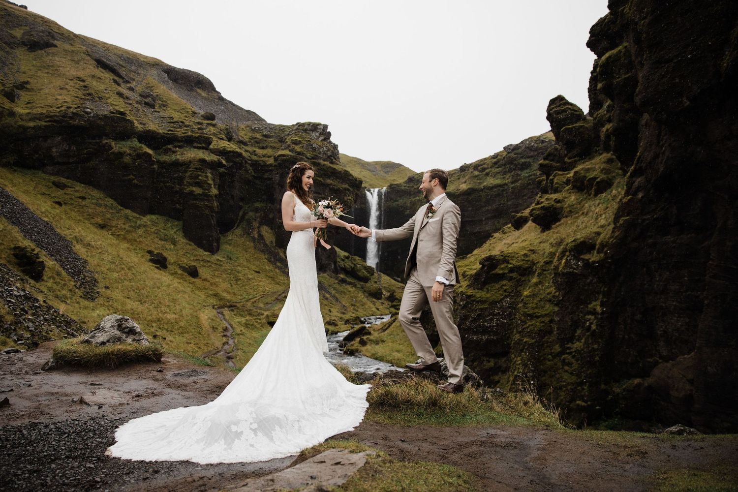 A romantic wedding photo captured against dramatic cliffs and mountains in Iceland.