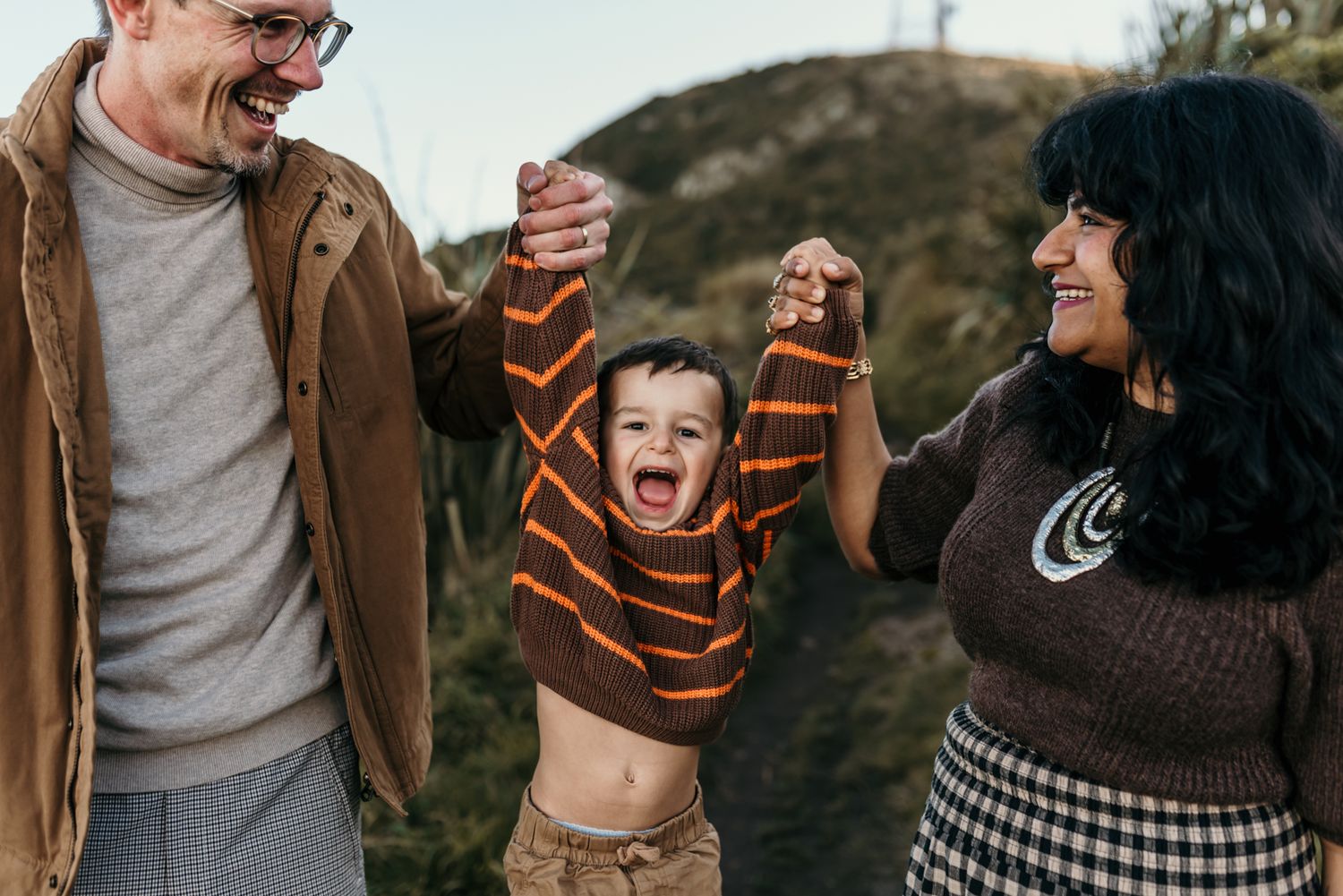 Joyful family moment captured outdoors with energetic child.