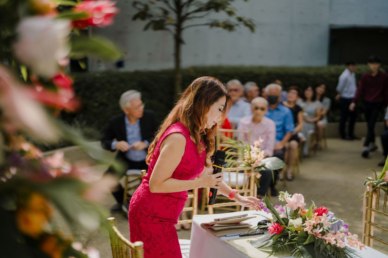Wedding reception setup with tables and chairs in an outdoor garden setting.