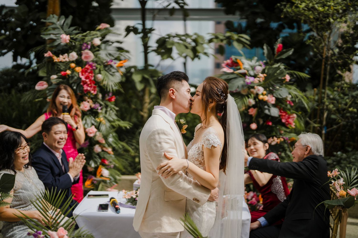 Wedding ceremony celebration in garden setting with vibrant flower arrangements.