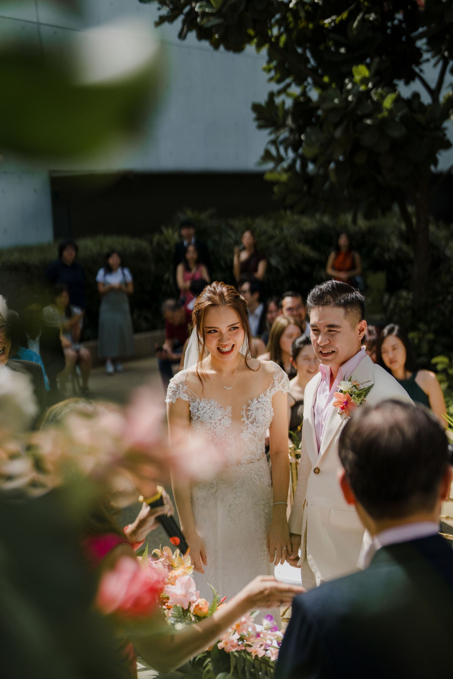 Wedding celebration in outdoor garden setting with guests and floral decor.