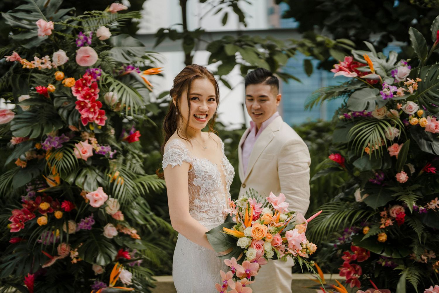 A romantic garden photoshoot surrounded by pink and red tropical flowers.