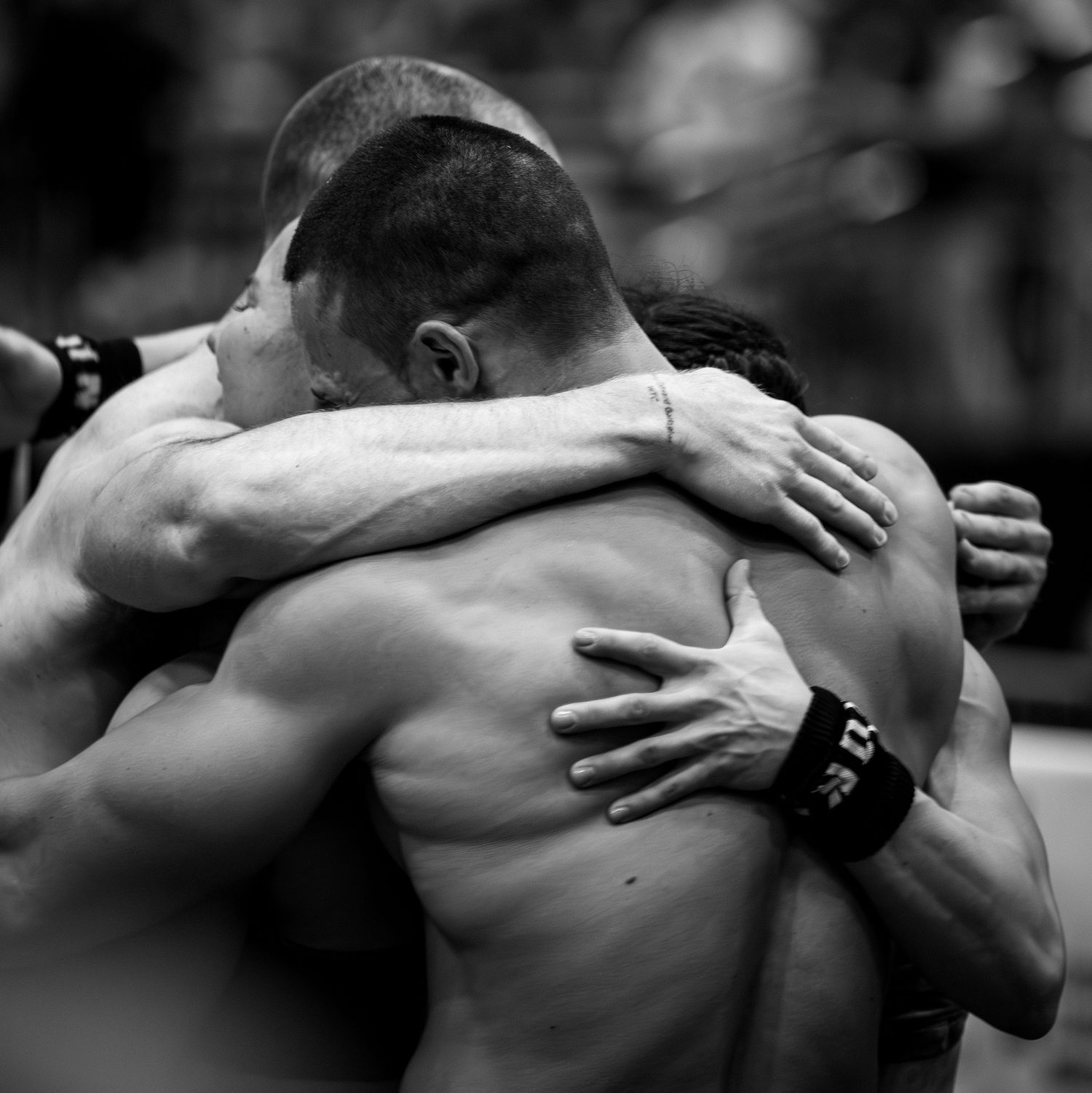 Two athletes share emotional embrace after intense competition showing raw sportmanship.