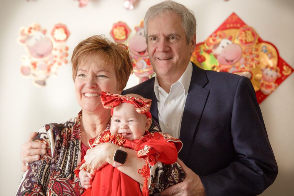 Family portrait in front of wall with Chinese New Year decorations.