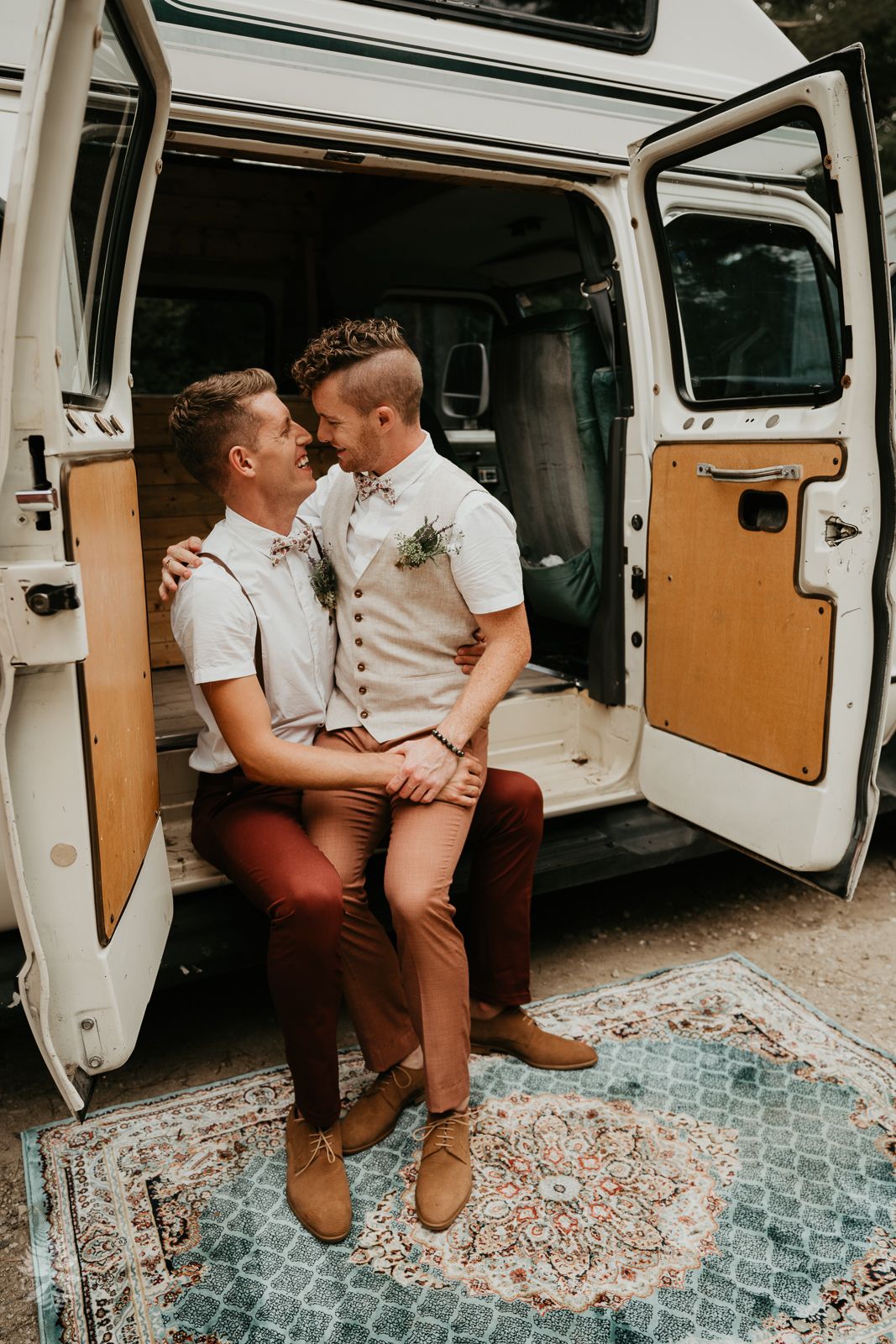 groom and groom sitting on side of van