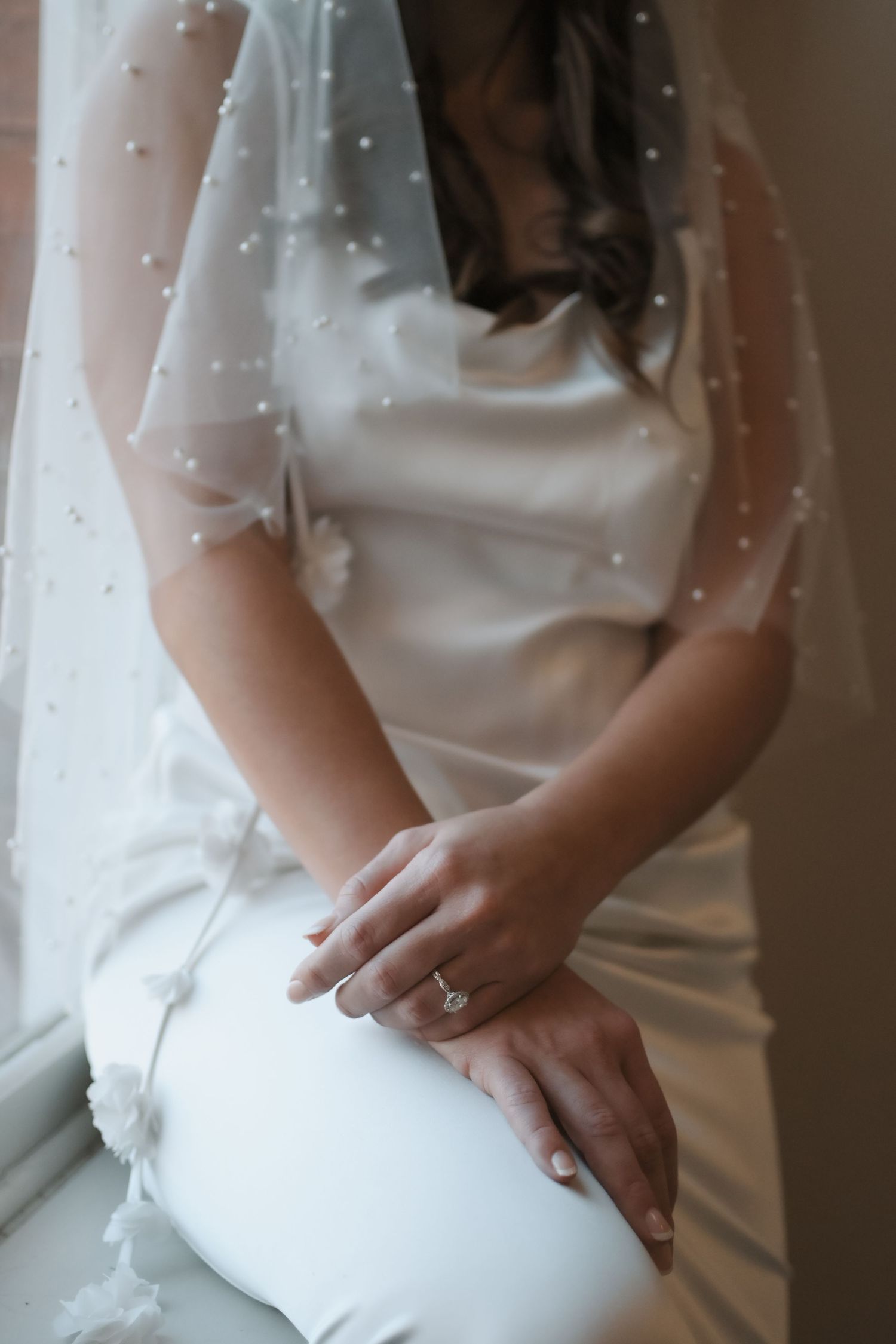 Close-up details of a white wedding dress with delicate beading and fabric textures.