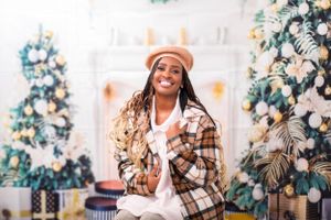 Holiday themed photography session with plaid outfit and decorated Christmas backdrop.