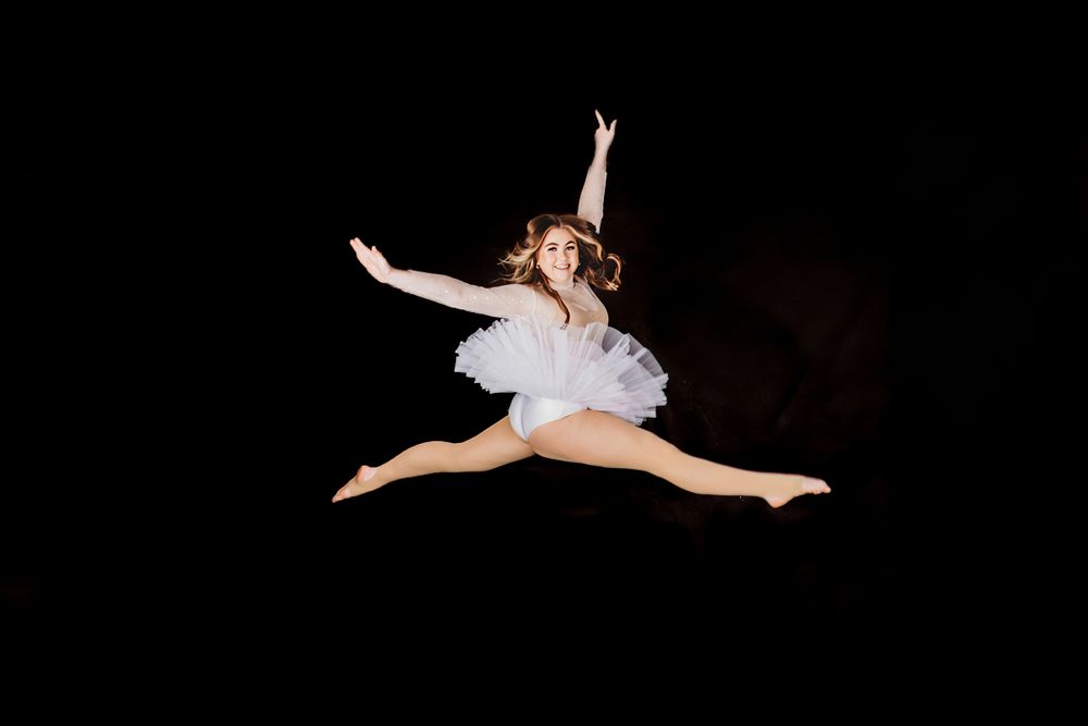 Artistic black and white dance poses against dark background.