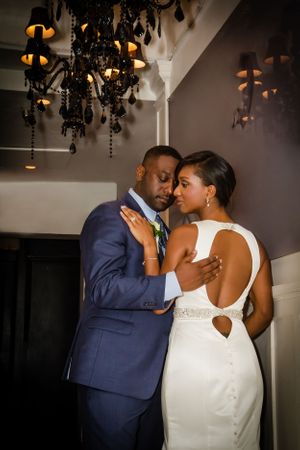A romantic wedding portrait under vintage chandeliers showing intimate moments between newlyweds.