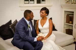 A couple shares romantic moments on their wedding day in an elegant white room.