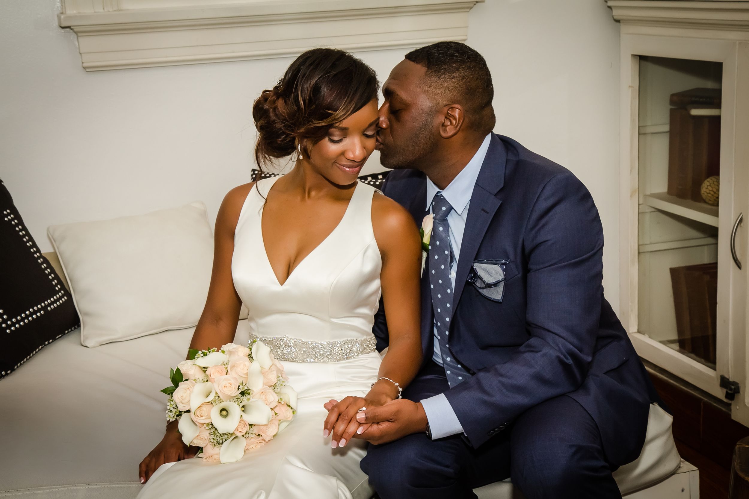 Couple shares tender moment on wedding day in elegant indoor setting.