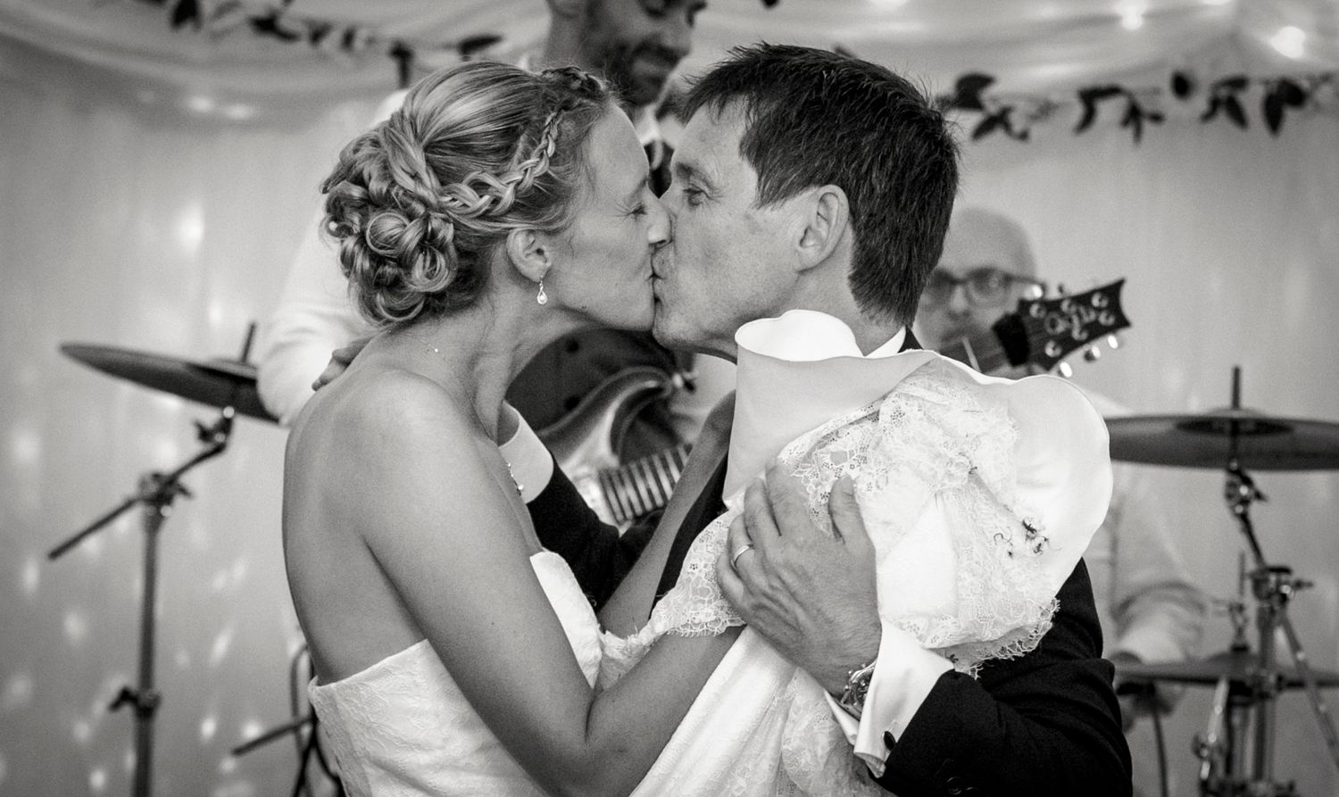 A romantic black and white photo of a couple sharing their first dance at a wedding reception.