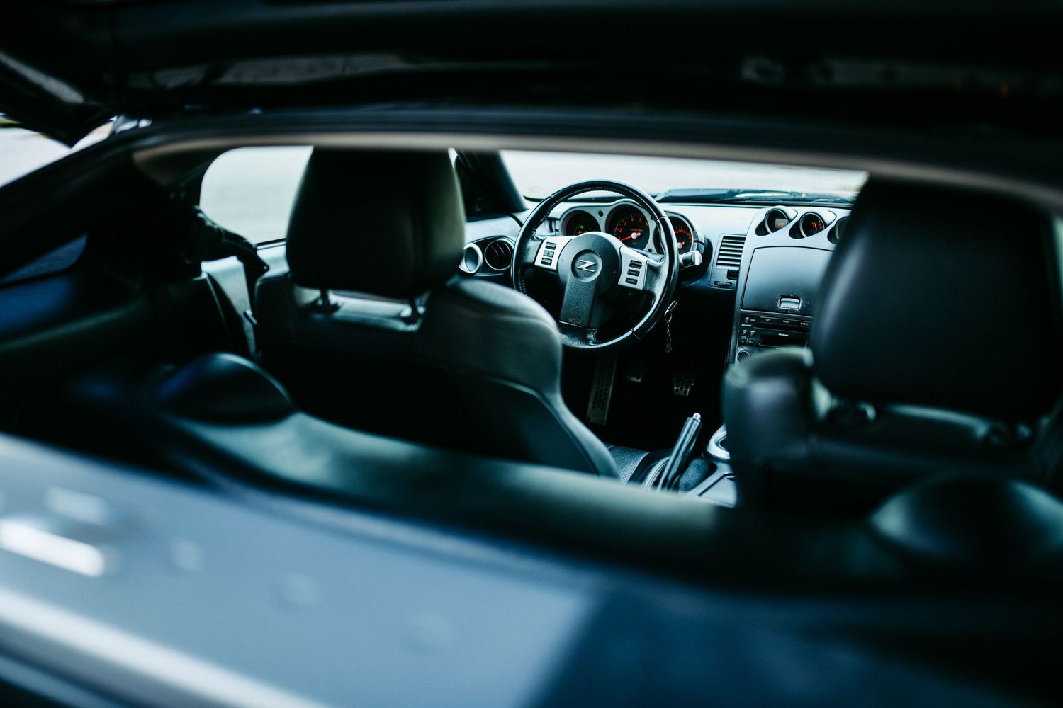 Interior view of a Nissan sports car showing dashboard and steering wheel.