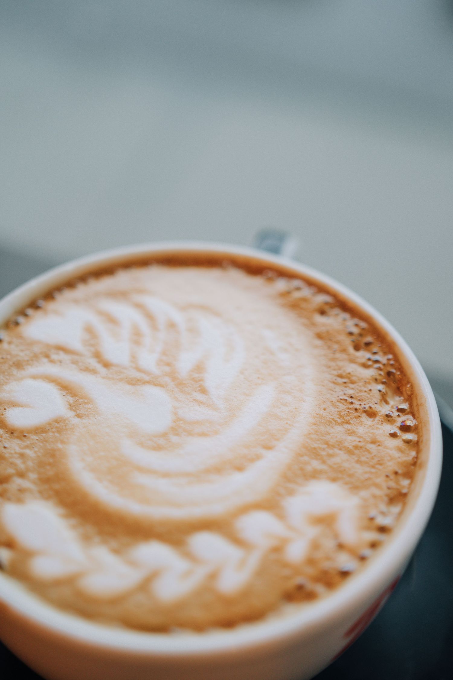 Close-up macro shots of latte art showing intricate swirl pattern in coffee foam.