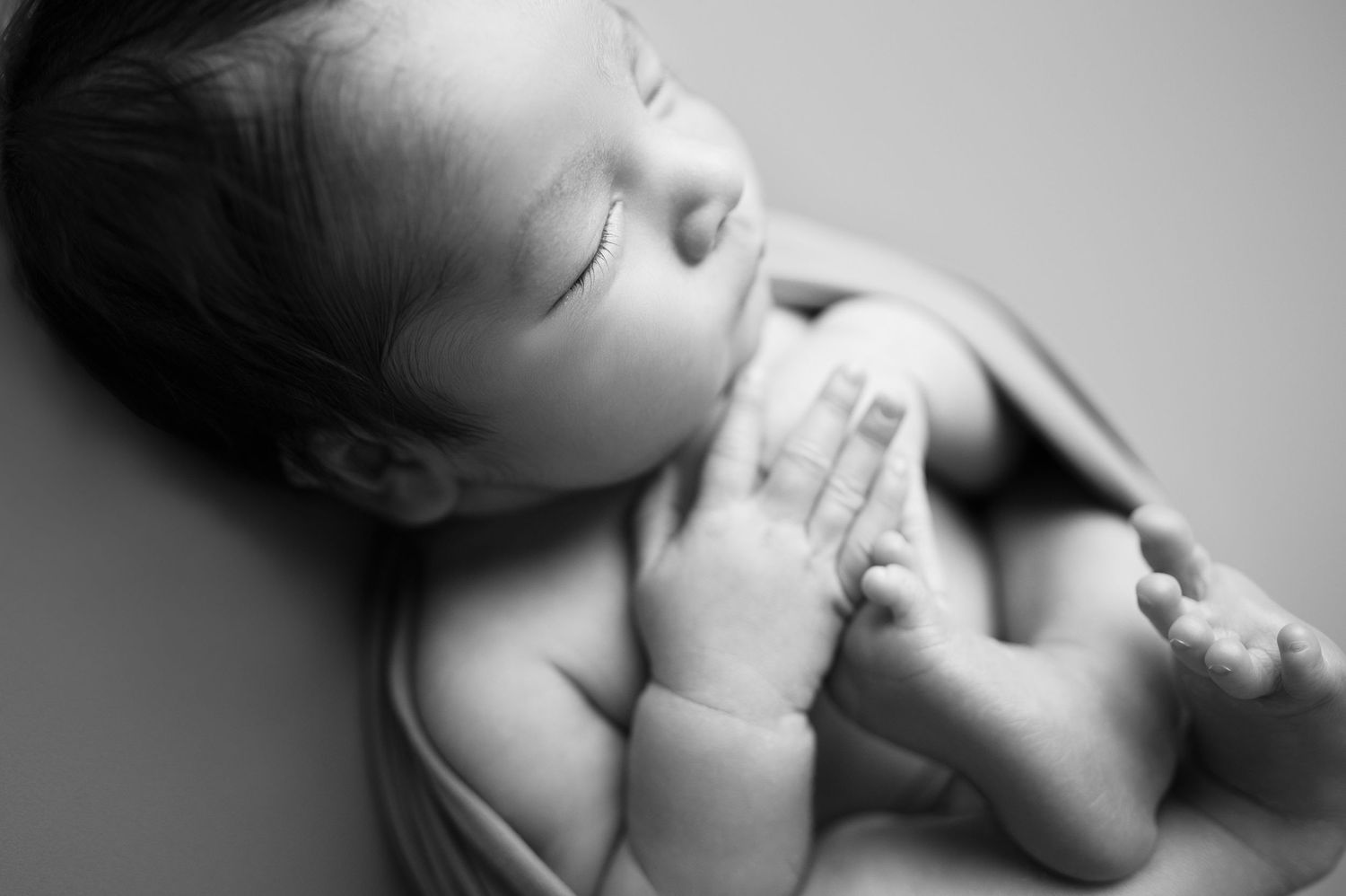 Black and white series of newborn baby photos showing peaceful sleeping poses.