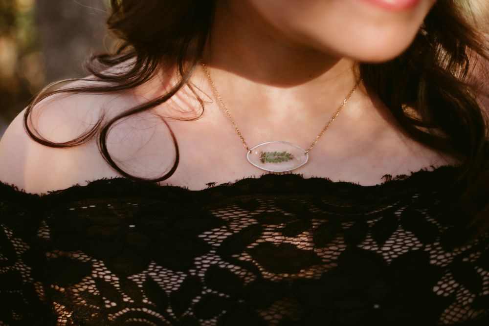 Close-up detail of delicate lace neckline with a dainty necklace.