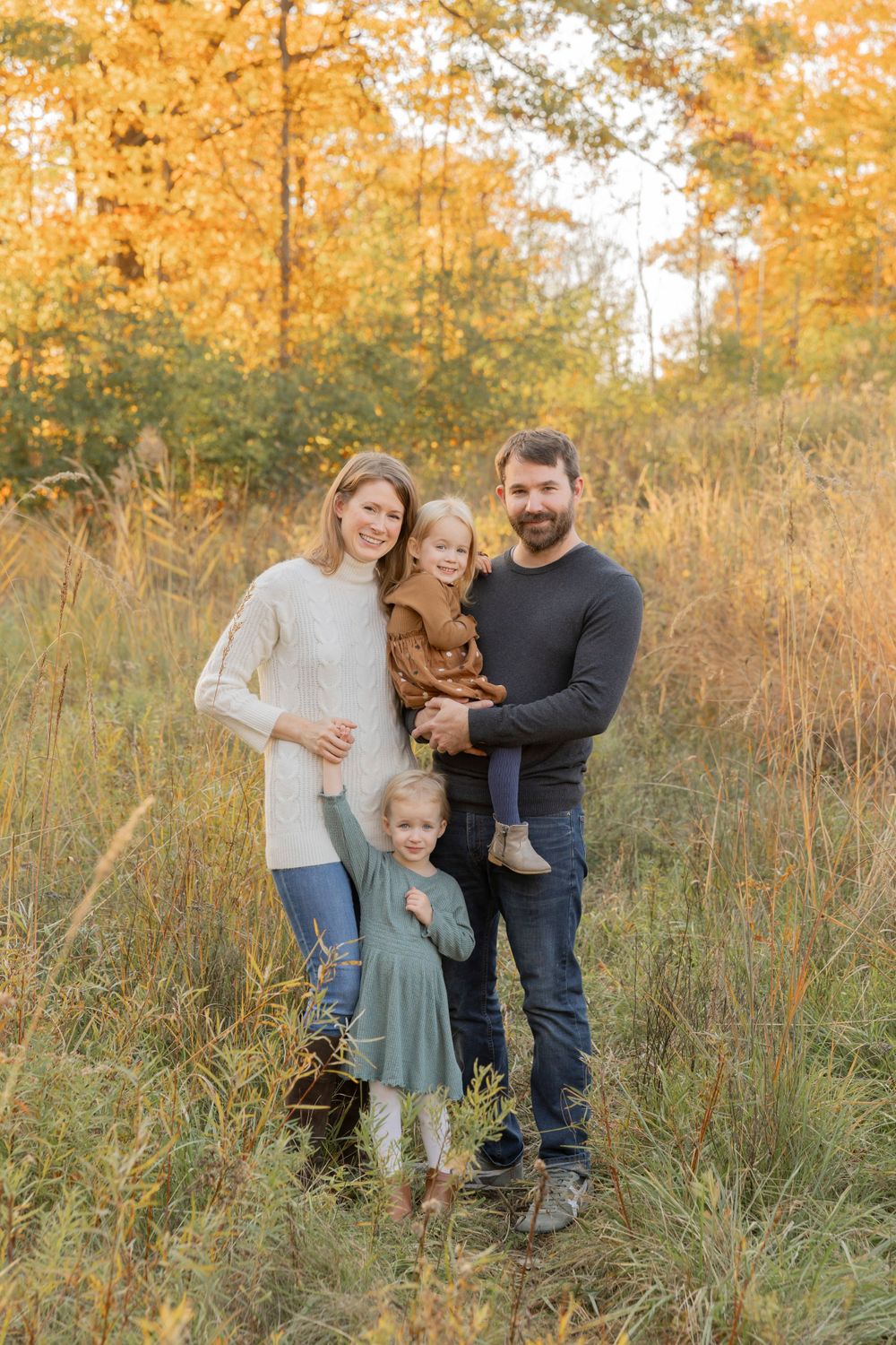family with twin girl smiling for a fall family photo at Douglas Evans nature preserve in Beverly Hills, Birmingham