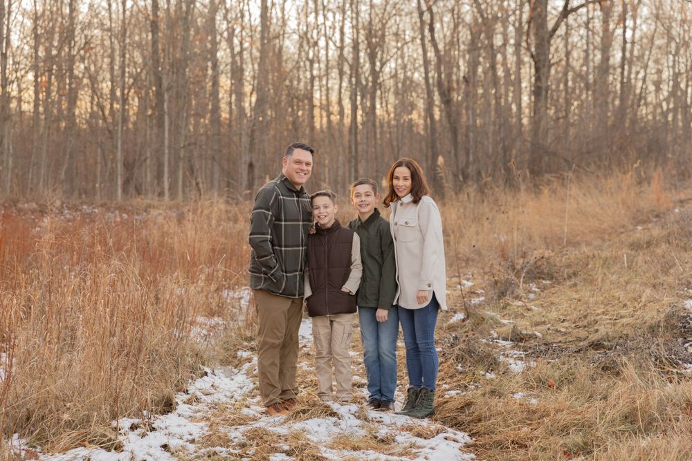 family of four standing in a field of grasses in winter in Beverly Hills michigan