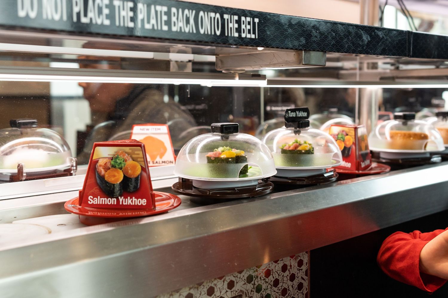 Conveyor belt with sushi plates at Kura Revolving Sushi Bar in Bellevue.