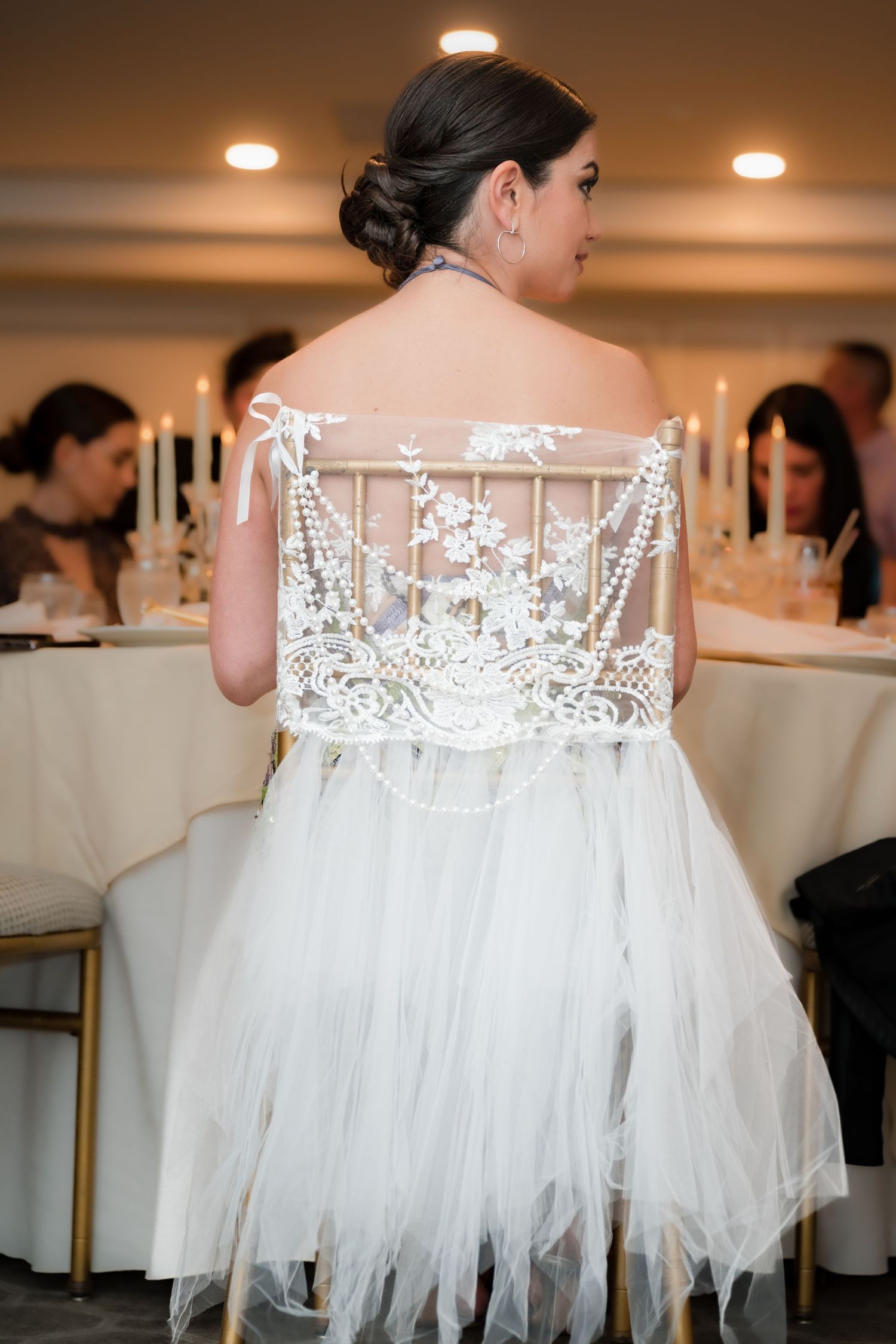 Back view of bride in detailed lace wedding dress with pearl embellishments.
