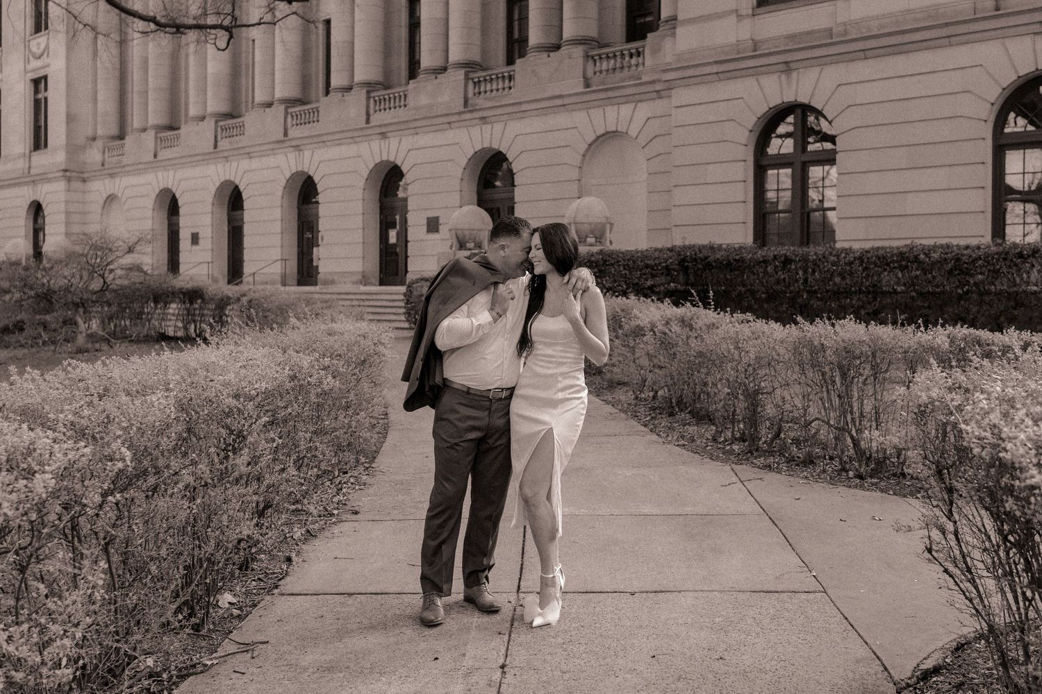 Engaged Couple snuggle up to each other during their engagement photos at Mecklenburg county's DA's office in Uptown Charlotte.
