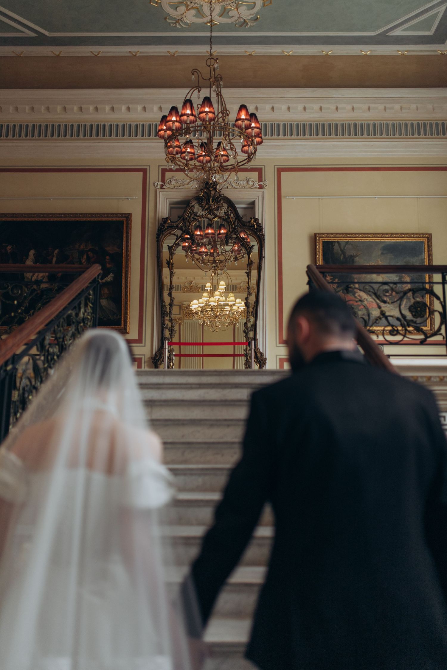 A romantic scene with chandelier lighting in an ornate historical building interior.