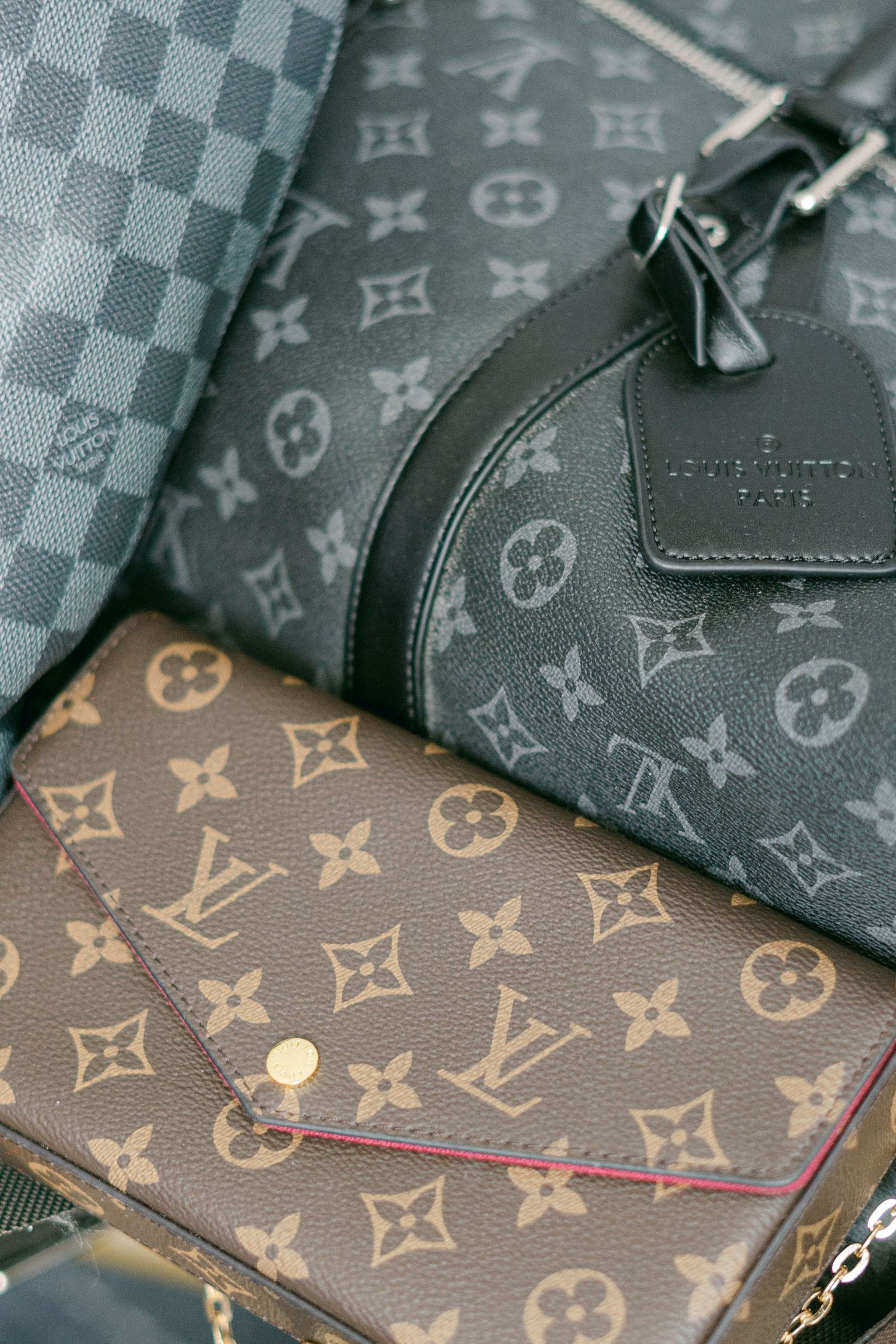 Close-up of Louis Vuitton monogram pattern accessories in black and brown.