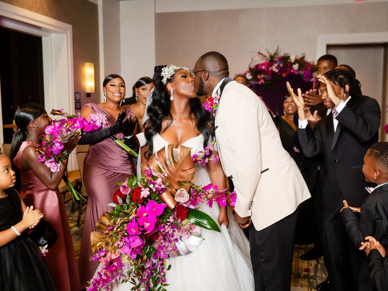 Wedding ceremony moment with vibrant pink and purple floral arrangements.