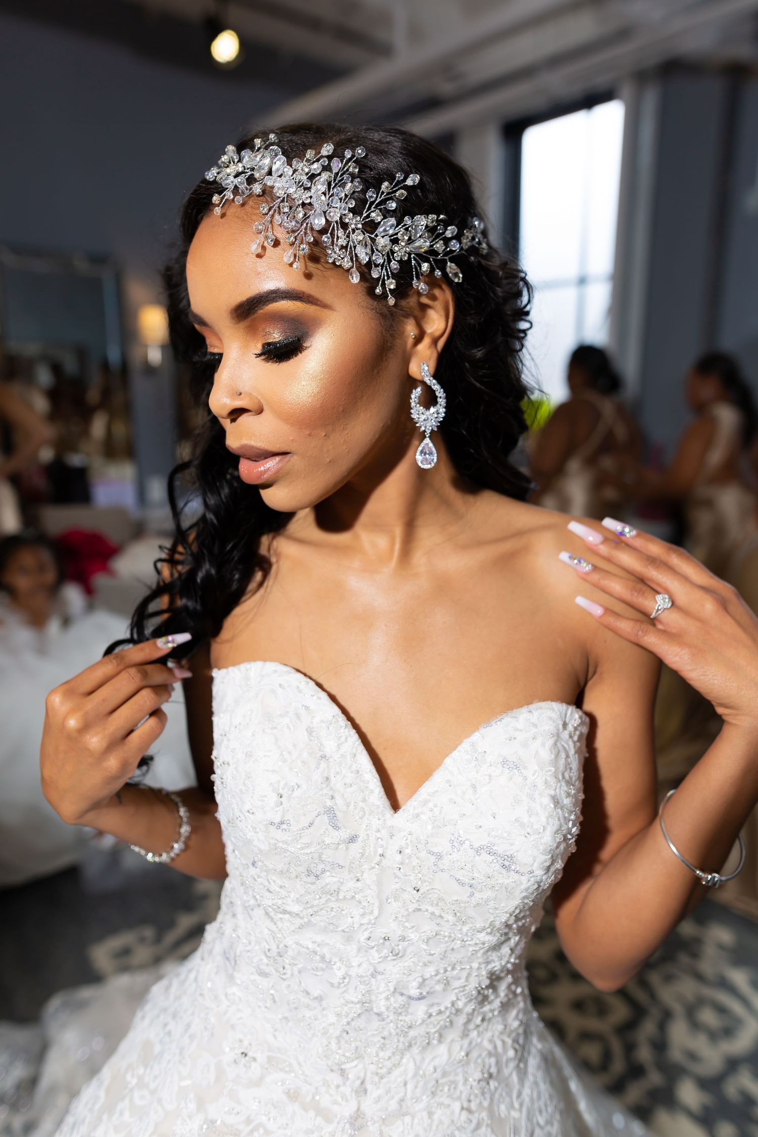 Close-up of bridal details showing crystal hair accessories and strapless lace wedding gown.
